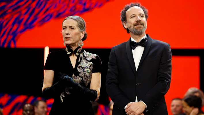 Carlo Chatrian, künstlerischer Direktor der Berlinale, und Mariette Rissenbeek, Geschäftsführerin der Berlinale, stehen während der Preisverleihung bei der Abschlussgala im Berlinale Palast auf der Bühne.