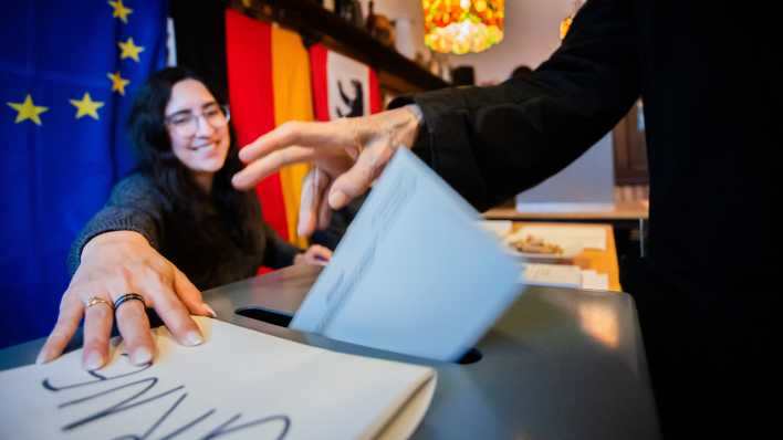 Eine Frau wirft ihren Stimmzettel in die Urne im Wahllokal 424 in der Kneipe Xantener Eck im Ortsteil Wilmersdorf.