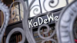 Durch ein Gitter vor einem Eingang des KaDeWe ist der Schriftzug des Kaufhauses zu sehen (Bild: picture alliance/dpa/Christophe Gateau)