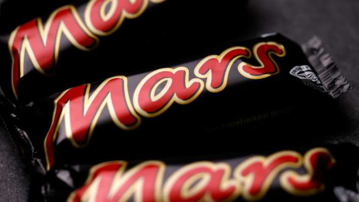 Mars-Schokoriegel liegen auf einer Steinplatte (Bild: picture alliance/Panama Pictures/Christoph Hardt)
