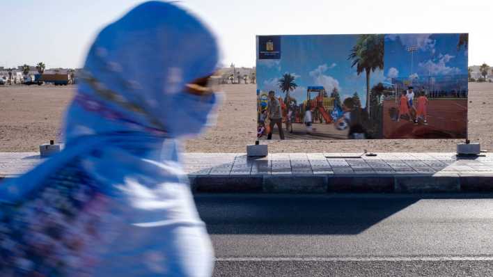 Leben in Ad-Dakhla Marokko - ein Frau geht verschleiert an einem Werbeplakat vorbei. Leben in Ad-Dakhla Marokko - ein Frau geht verschleiert an einem Werbeplakat vorbei.