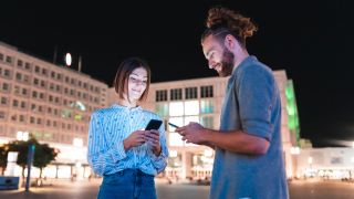 Touristenpärchen mit Smartphones in Berlin