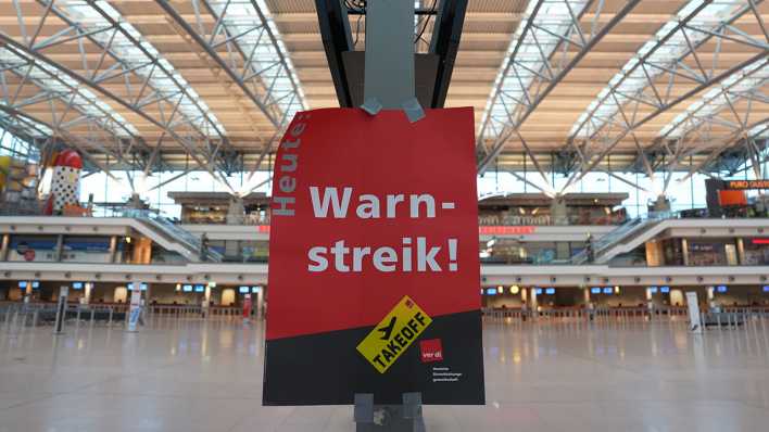 Ein Schild mit der Aufschrift "Warnstreik!" hängt im Terminal 1 im Flughafen Hamburg Airport.