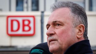 Claus Weselsky, Bundesvorsitzender der GDL, vor einem Logo der DB.