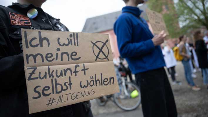 Eine Teilnehmerin hält während einer Demonstration für die Absenkung des Wahlalters auf 16 Jahre ein Schild, auf dem "Ich will meine Zukunft selbst wählen #altgenug" steht (Bild: picture alliance/dpa/Sebastian Gollnow)