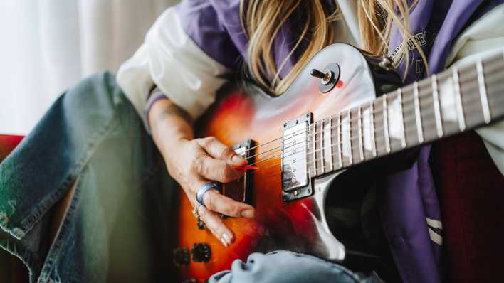 Eine Frau spielt E-Gitarre.