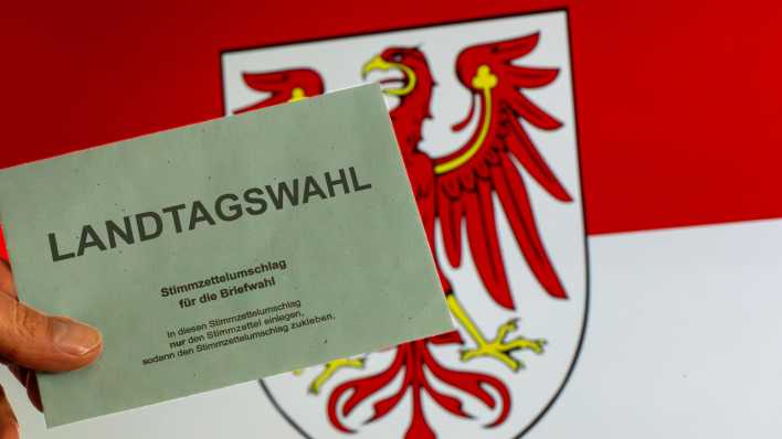 Symbolbild Landtagswahl in Brandenburg: Umschlag zur Briefwahl vor dem Wappen von Brandenburg (Bild: picture alliance / CHROMORANGE | Udo Herrmann)