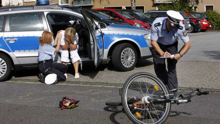 Polizeibeamte betreuen Zeugen eins Fahrradunfalls
