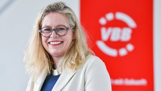 Porträt von Ute Bonde vor dem Logo des VBB