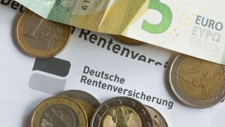 Münzen liegen auf einer Renteninformation der Deutschen Rentenversicherung.