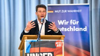 Der Politiker René Aust auf einer Bühne.
