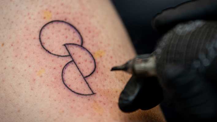 Bei einer Aktion der Organisation "Junge Helden" lässt sich eine Person ein Organspende-Tattoo stechen.