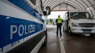 Ein Beamter der Bundespolizei beobachtet einen Kleinbus während einer Kontrolle am Grenzübergang an der Kontrollstelle der Bundesautobahn A4.