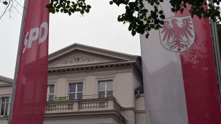 Fahnen der SPD und Brandenburgs wehen vor der Brandenburger SPD Parteizentrale in Potsdam. (Bild: picture alliance/dpa/Michael Bahlo)