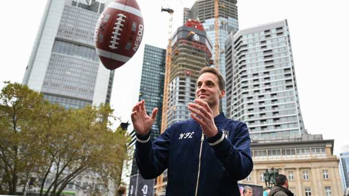 Alexander Steinforth, General Manager der NFL Deutschland, fängt während eines Pressetermins einen Football.