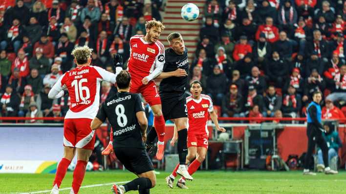 Union Berlins Yorbe Vertessen (Mitte l) geht zum Kopfball gegen Freiburgs Matthias Ginter (Mitte r).