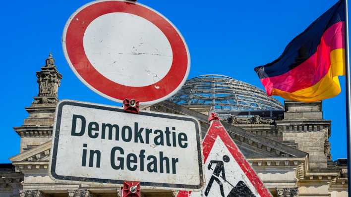 Schild mit der Aufschrift: "Demokratie in Gefahr" Schild mit der Aufschrift: "Demokratie in Gefahr"