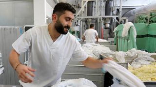 Der 24-jährige Obada Sakkaoui aus Syrien arbeitet im Textil-Dienstleistungsunternehmen Sitex in Rostock. (Archivbild)