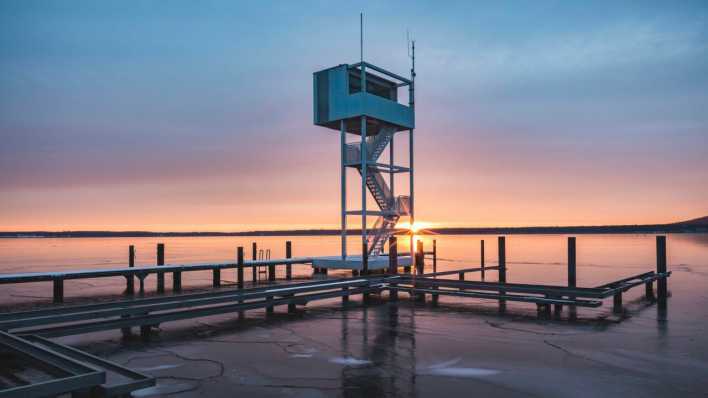 Berliner Müggelsee mit Sprungturm beim Sonnenuntergang im Winter (Bild: picture alliance/Westend61/Anke Scheibe)
