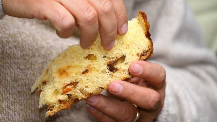 Mann isst eine Scheibe Panettone