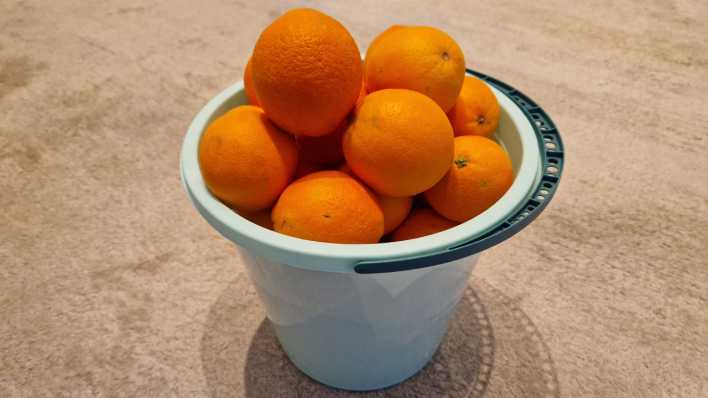 Orangen liegen in einem Eimer - ein Stapel wie eine Pyramide.