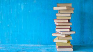 EIn Stapel mit vielen Büchern steht vor einem blauen Hintergrund (Bild: picture alliance / Shotshop / luftquallenpapst)