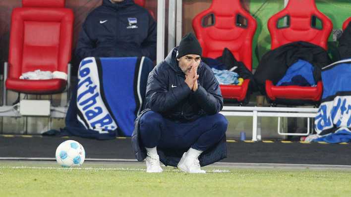 Der Herthaner Trainer Cristian Fiel hockt am Boden.