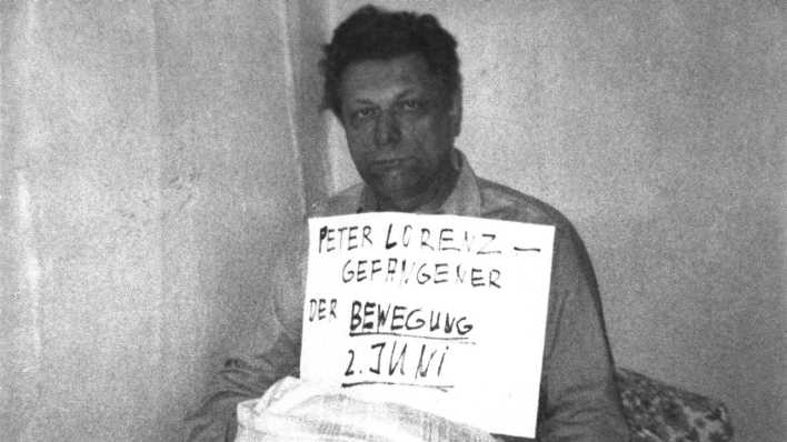 Peter Lorenz mit dem Schild um den Hals.