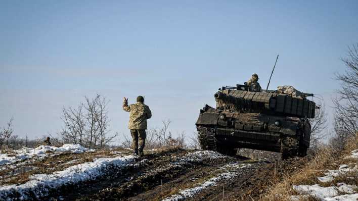 Ein Panzer fährt während einer militärischen Übung in der Ukraine über einen Feldweg.
