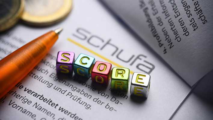 Buchstabenwürfel bilden das Wort Score auf einem Formular der Schufa