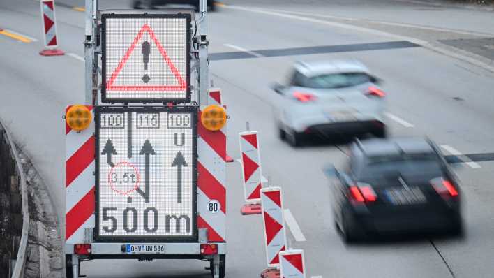 Autos fahren auf der A100 in Richtung Messe an einem Schild vorbei, das die Umleitung um die gesperrte Ringbahnbrücke anzeigt.