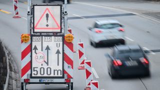 Autos fahren auf der A100 in Richtung Messe an einem Schild vorbei, das die Umleitung um die gesperrte Ringbahnbrücke anzeigt.