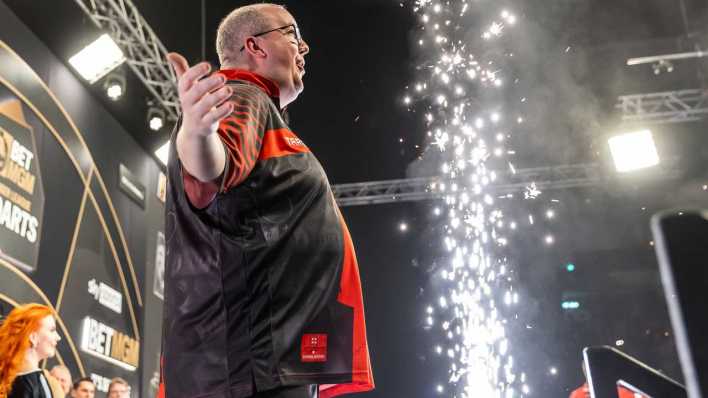 Berlin, 3.4.25: Darts: Premier League, Stephen Bunting steht mit erhobenen Armen vor den Zuschauern (Bild: picture alliance/dpa/Andreas Gora)