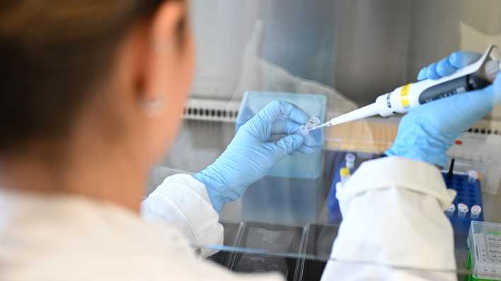 Ein Mitarbeiterin des Deutschen Krebsforschungszentrum arbeitet mit einer digitalen Pipette.