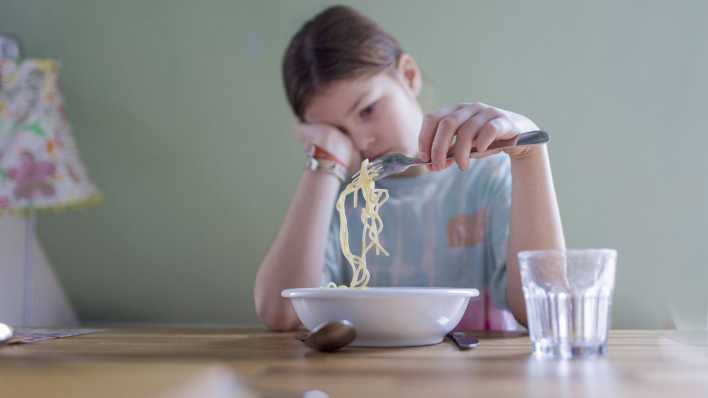 Mädchen lustlos vor einem Teller Spaghetti (Bild: IMAGO/Ute Grabowsky/photothek.de)