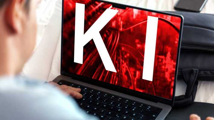 Ein Nutzer arbeitet am Laptop, während der Bildschirm das Kürzel KI und ein digitales Netzwerk in rotem Design zeigt (Bild: IMAGO/Michael Bihlmayer)