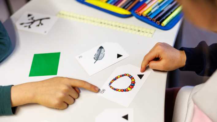 Kinder bearbeiten eine Aufgabe in der Schule, die mit Bildern zu tun hat.