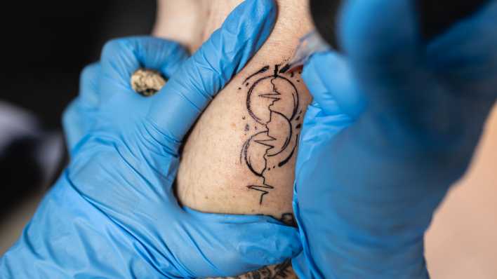 Ein Tattoo wird gestochen als Zeichen für die Organspendebereitschaft (Bild: IMAGO/Lars Heidrich)