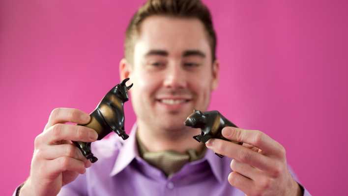 Junger Mann mit Figuren von Bulle und Baer (Bild: picture alliance / photothek / Ute Grabowsky)
