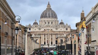 Blick auf den Petersdom über die Via della Conciliazione, tausende Menschen gehen in Richtung des Vatikans.