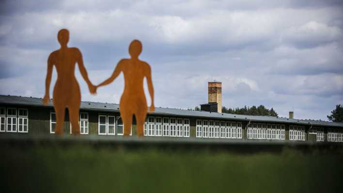 Ein Denkmal in der Gedenkstätte Sachsenhausen zeigt zwei Personen, die einander an der Hand halten.