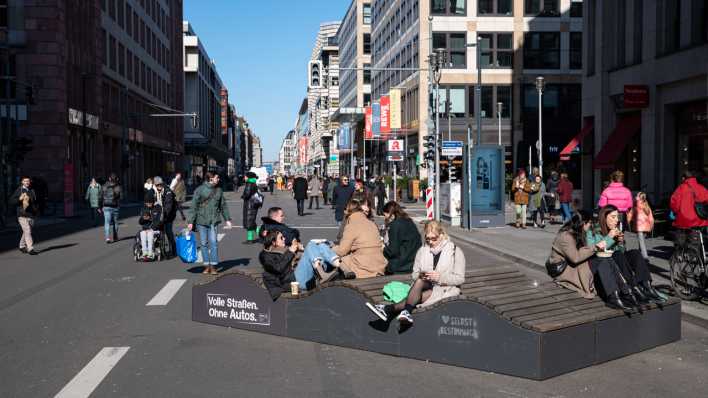 Fussgänger gehen im Berliner Bezirk Mitte über die autofreie Friedrichstrasse