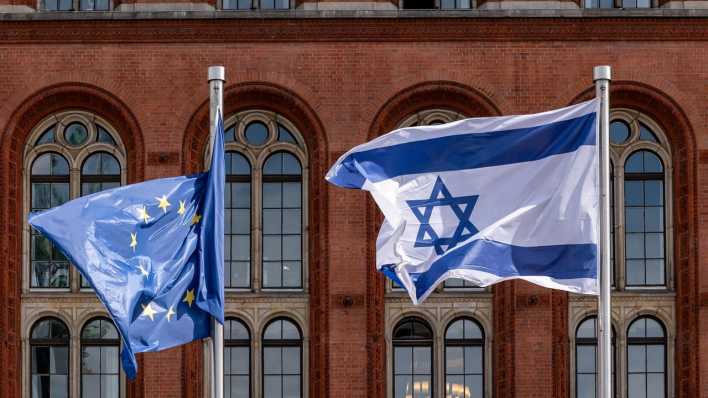 Die Flaggen der Europäischen Union und Israels wehen Seite an Seite vor dem Roten Rathaus in Berlin.