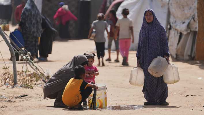 Palästinensische Frauen füllen Wasserbehälter in einem Flüchtlingscamp in Chan Yunis auf.