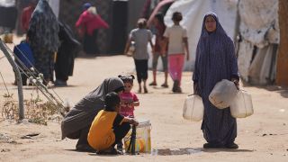 Palästinensische Frauen füllen Wasserbehälter in einem Flüchtlingscamp in Chan Yunis auf.