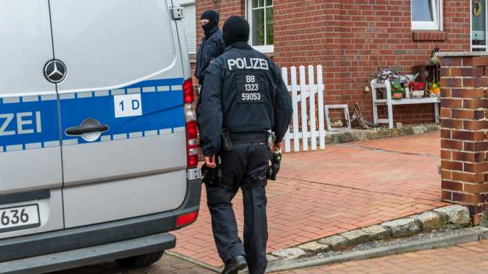 Polizisten durchsuchen ein Haus in Altdöbern.