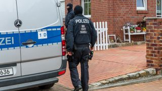 Polizisten durchsuchen ein Haus in Altdöbern.