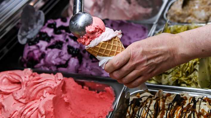 Eine Kugel Eis wird in einer Berliner Eisdiele in eine Waffel gesetzt