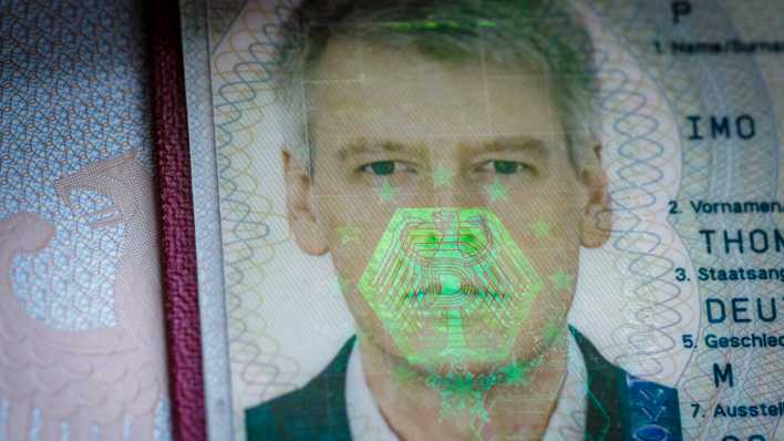 Auf dem biometrischen Passfoto eines Reisepasses spiegelt sich ein Bundesadler als Hologramm (Bild: picture alliance/photothek/Thomas Trutschel)