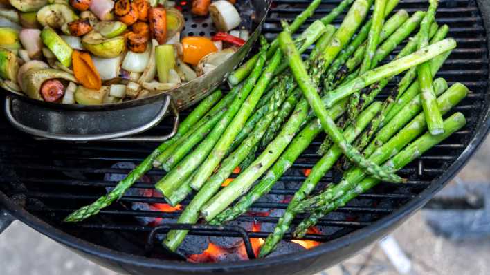 Gemüse sowie Grüner Spargel liegen auf einem Kugelgrill